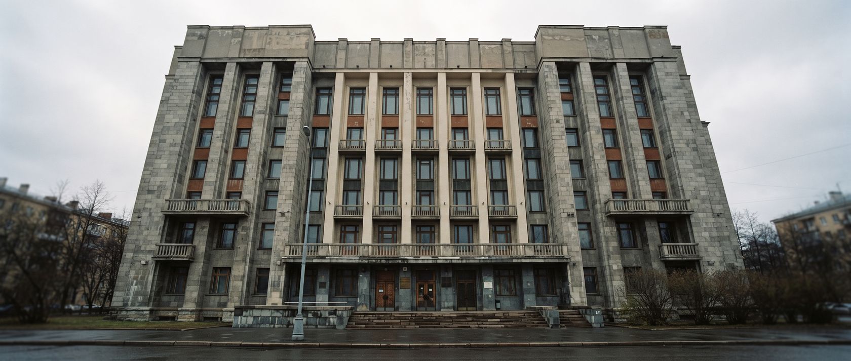 Фасад строгого административного здания с высокими узкими окнами, съемка снизу